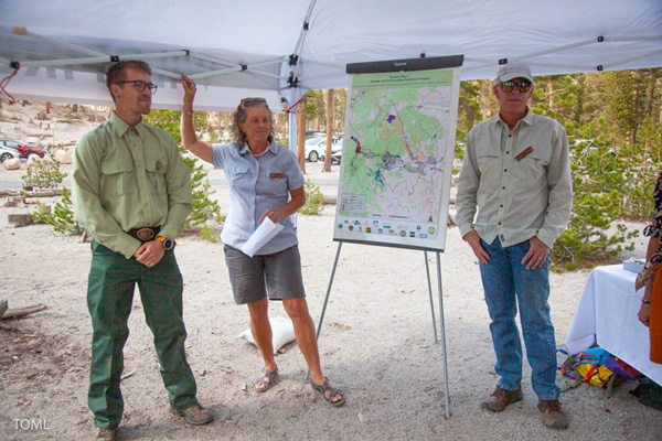 three people standing next to a map