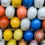 a bunch of hard hats hang on a wall