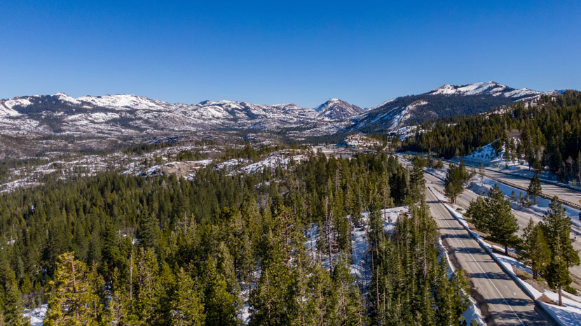 aerial view looking out along highway with snowy mountains in the background