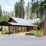 A small community building with a road in the foreground and surrounded by trees.