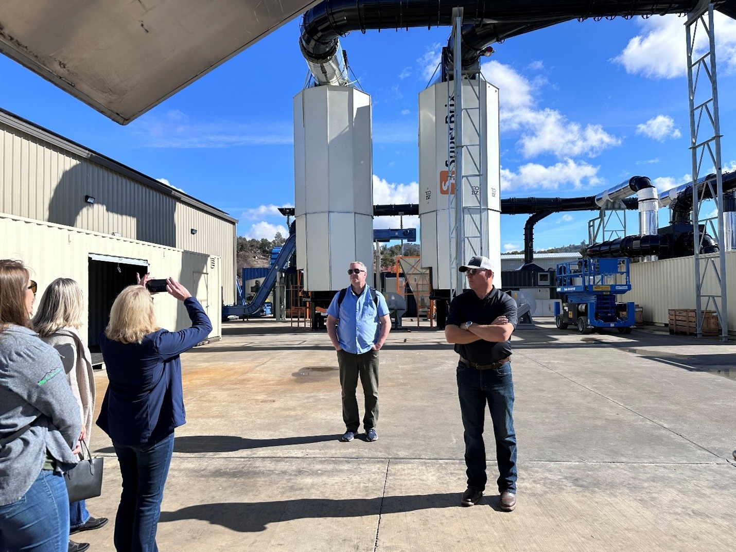 A group of five people tour an outdoor facility