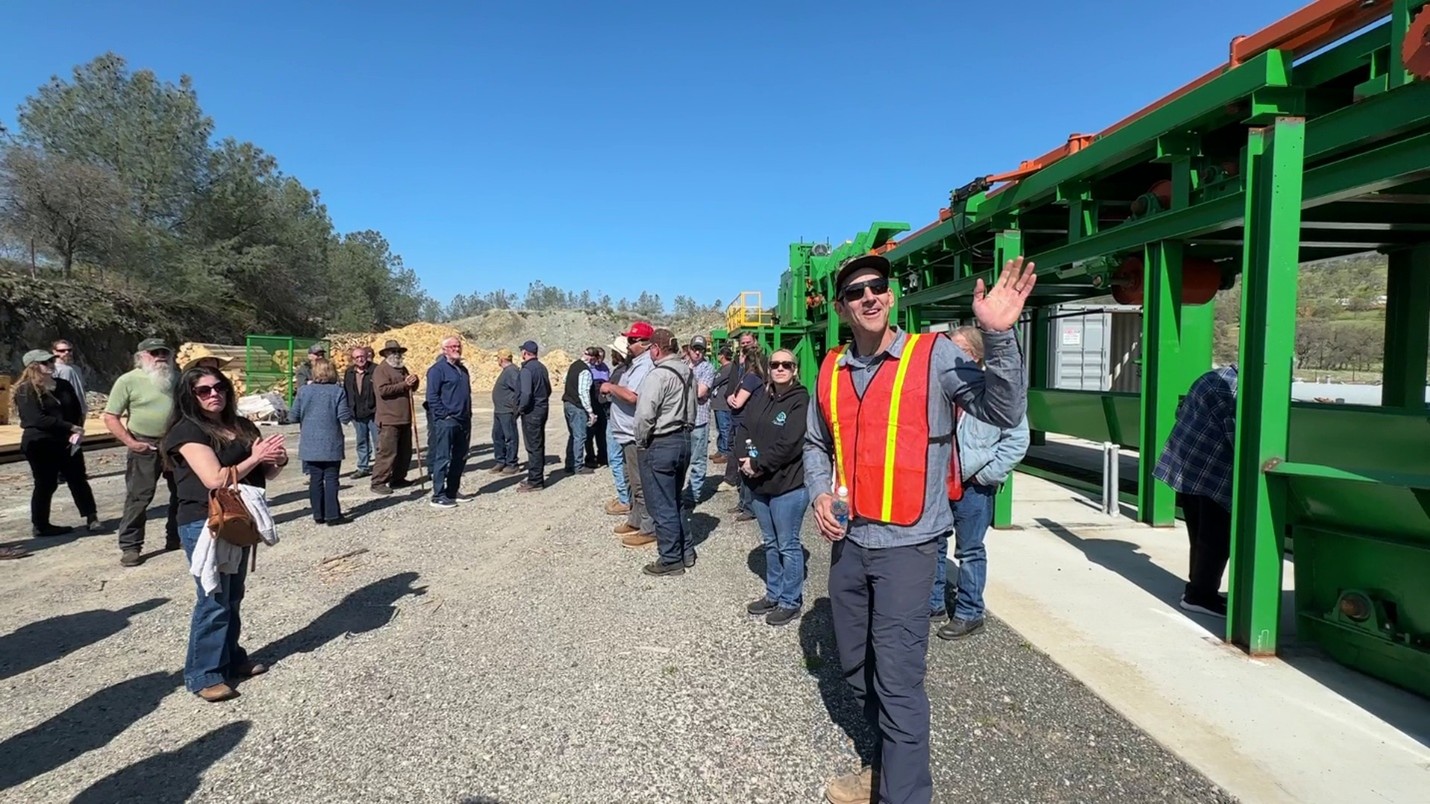 A group of about a dozen people touring an outdoor facility