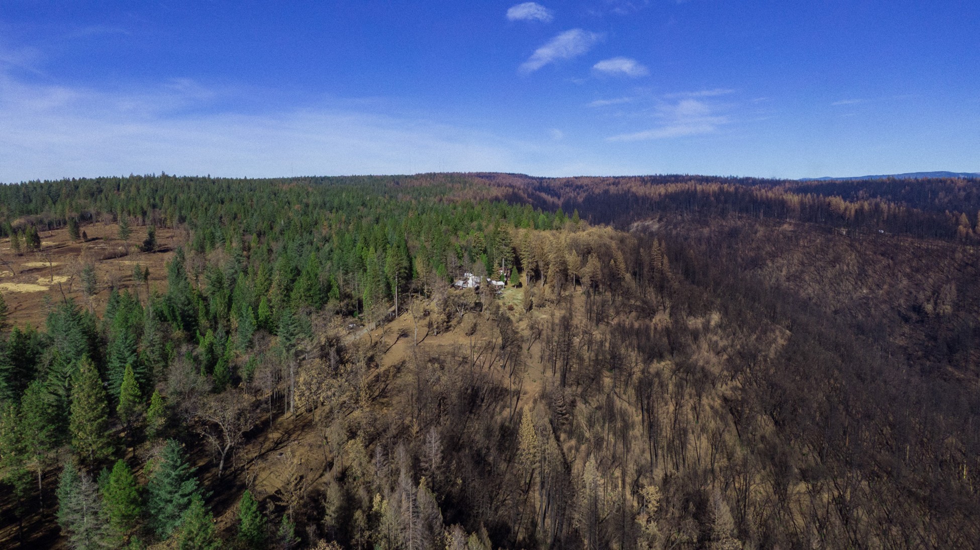 An aerial shot of a small outpost the mountains among trees