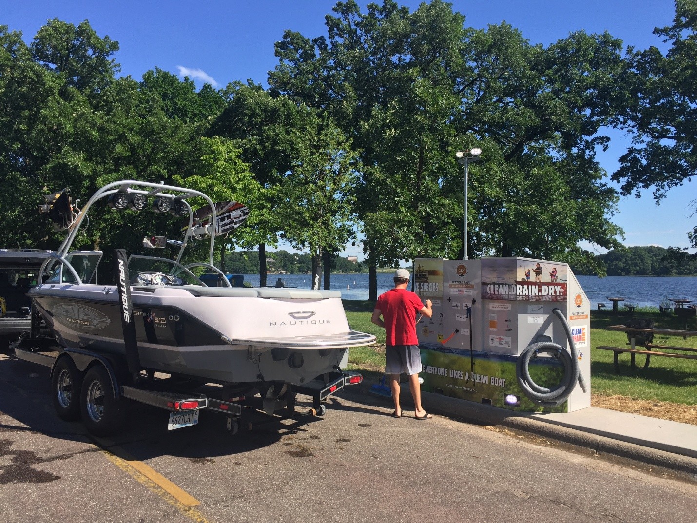 A recreational boat on the road next to a roadside cleaning station